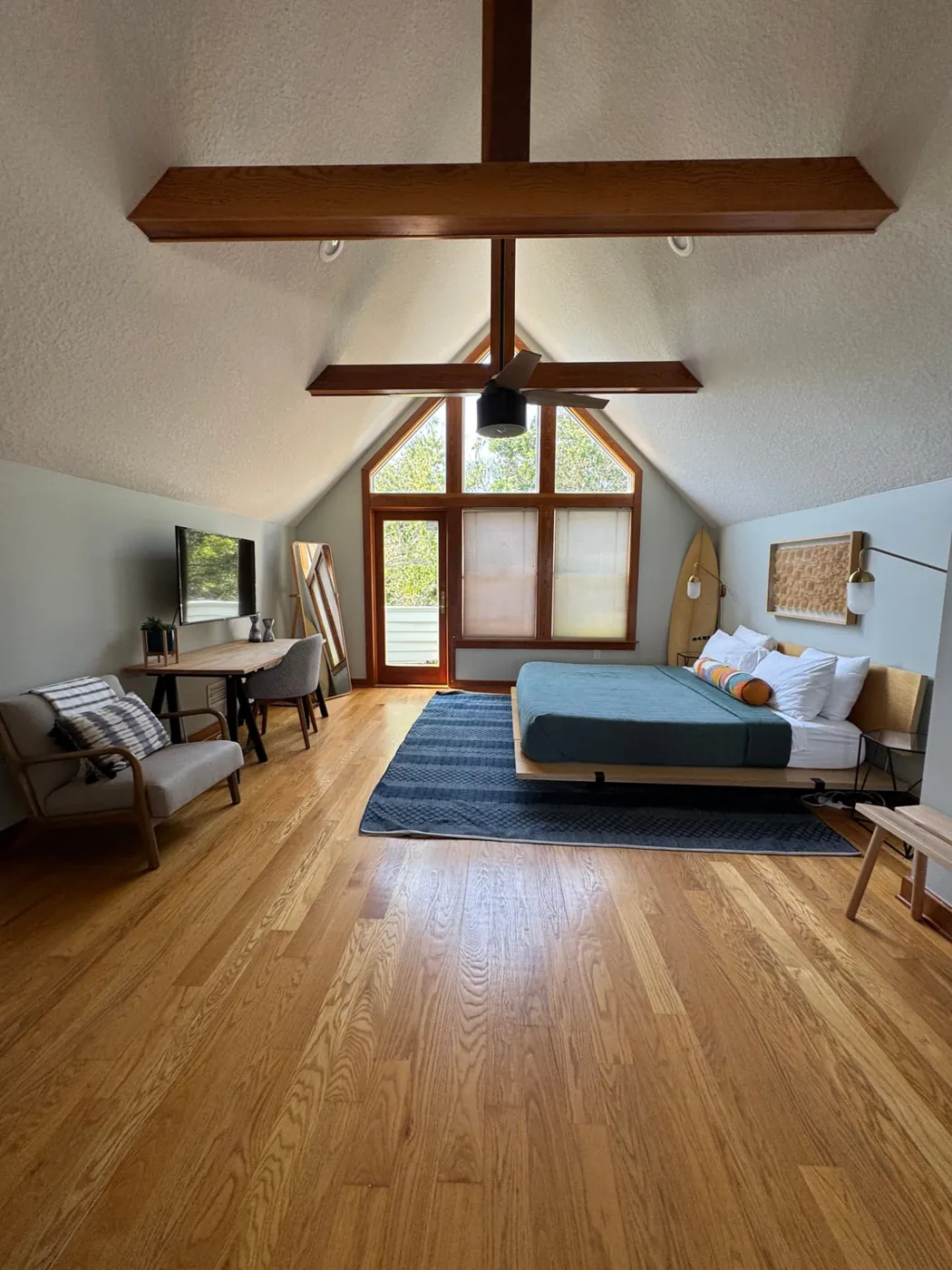 Loft bedroom with polished hardwood floors prepared for guests