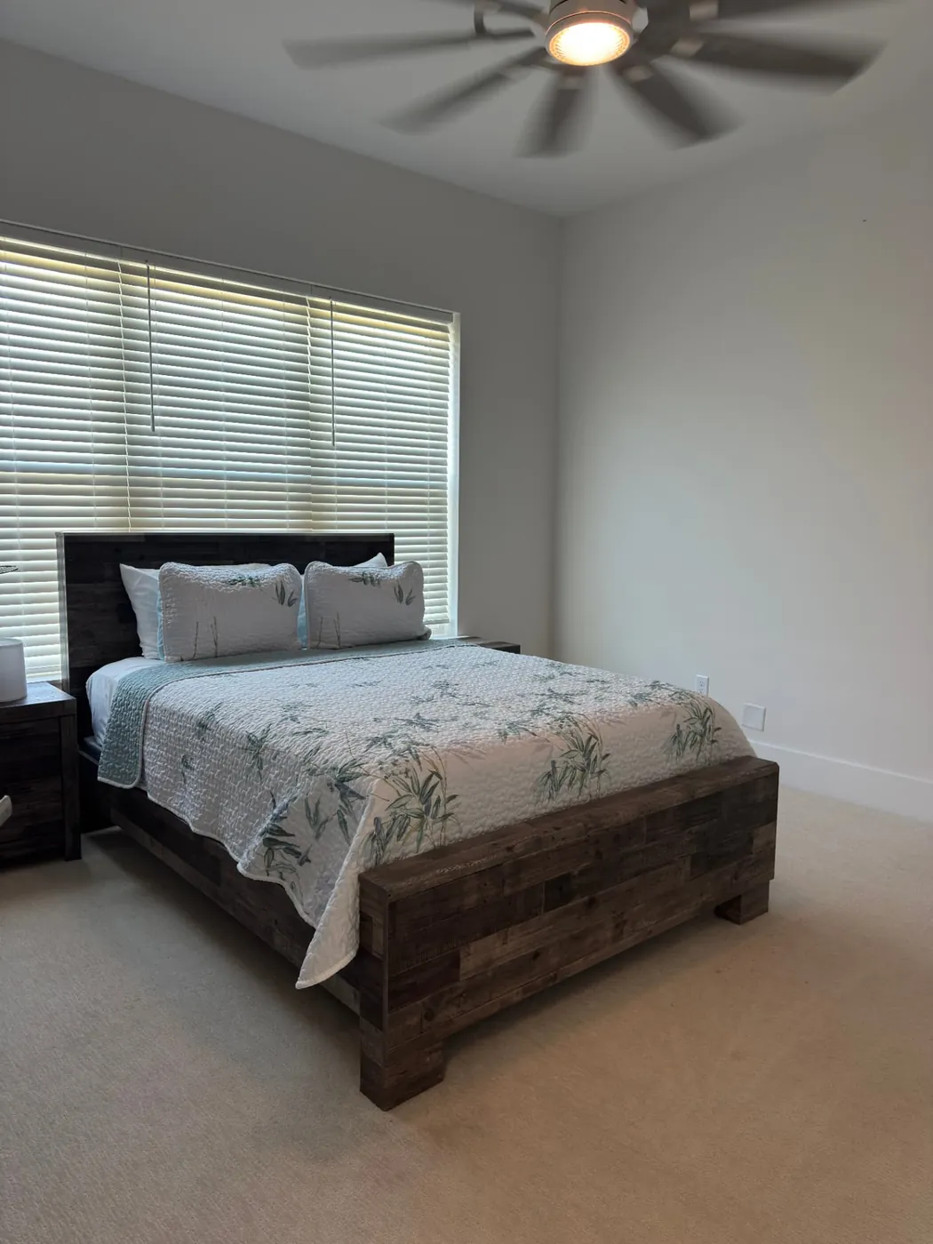 Guest bedroom with a neatly made rustic wood bed after a cleaning